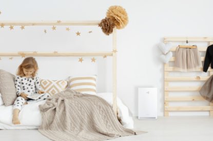 a photo of child reading a book in her beautiful room with Daikin air purifier